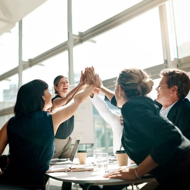 Groupe de jeunes célébrant une réussite autour d'une table
